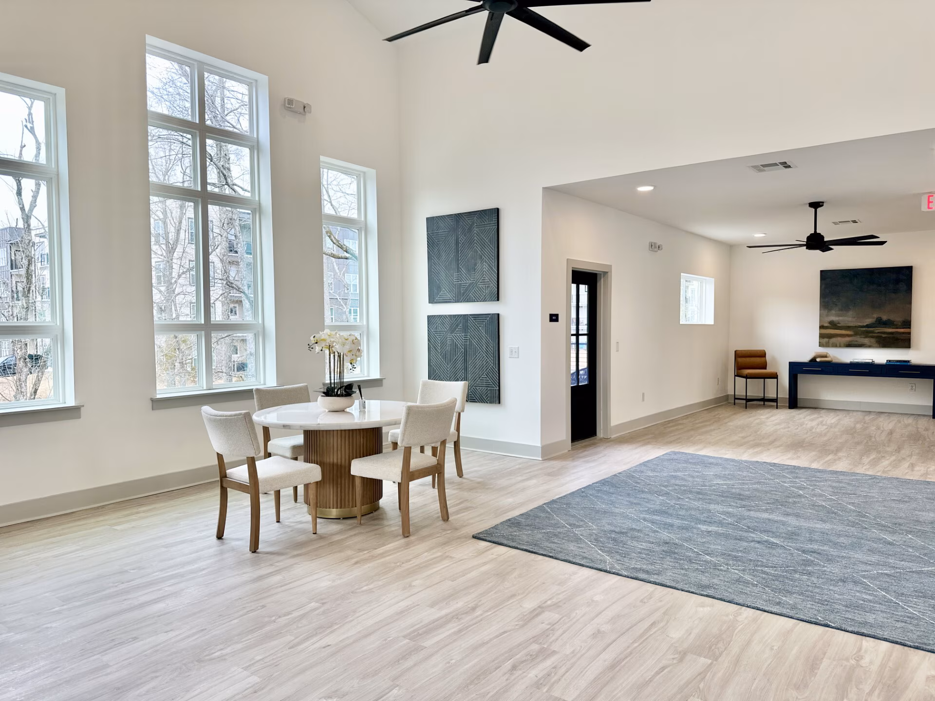 Resident lounge with tall windows and a dining table
