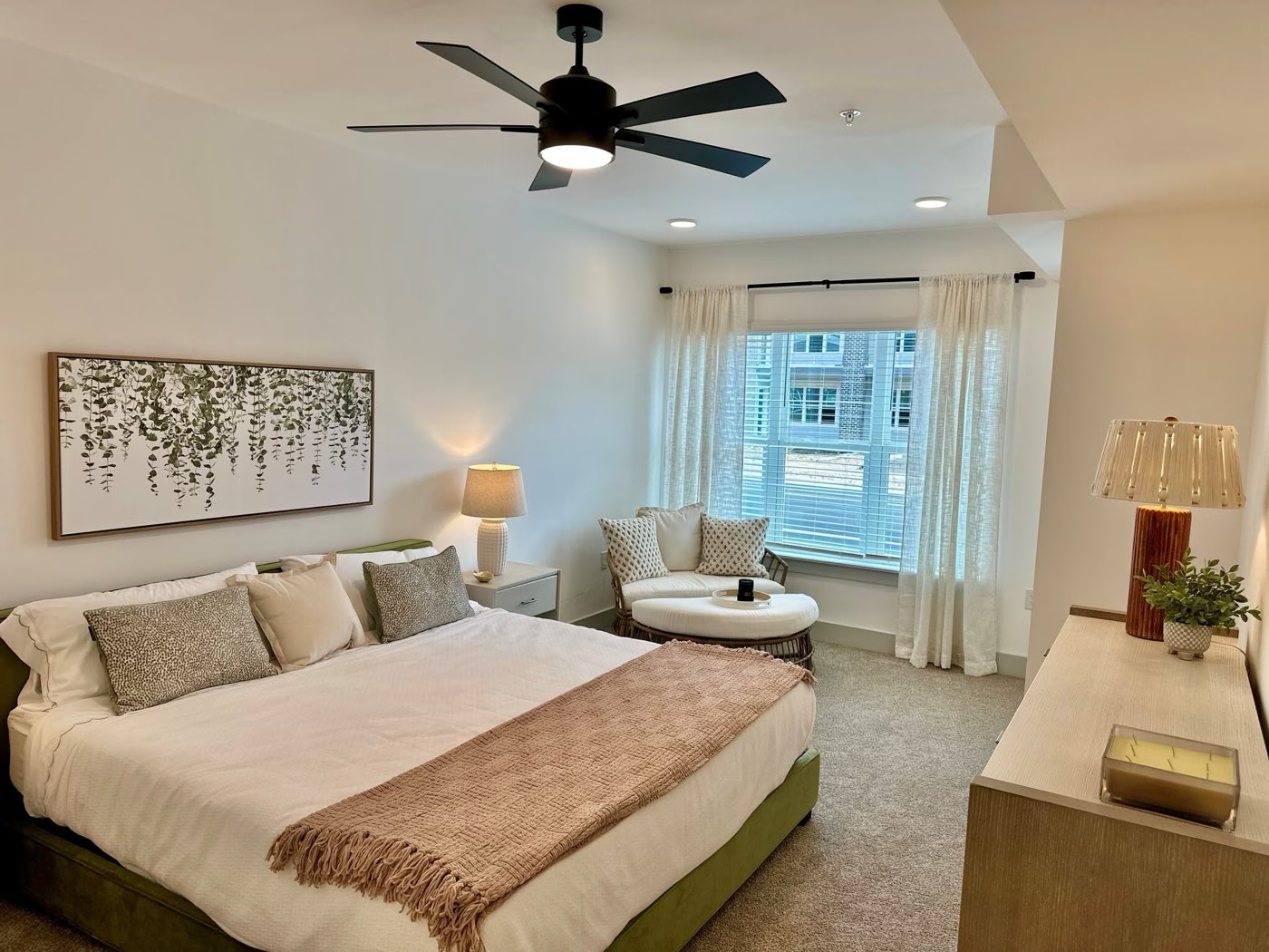 Primary bedroom with a ceiling fan and window seating
