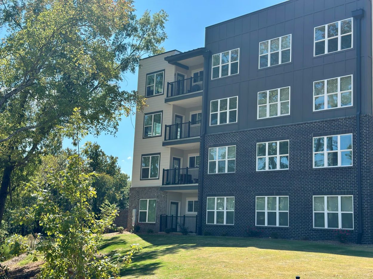 Apartment building exterior above a green lawn